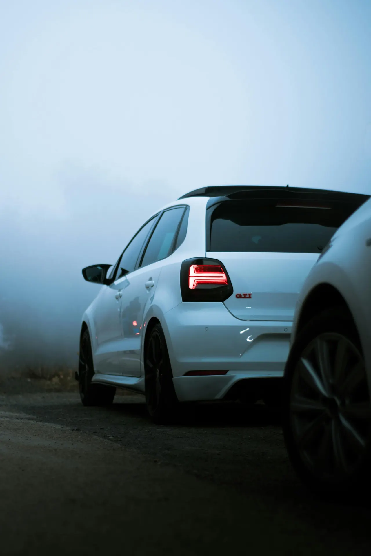 Volkswagen Polo GTI branco, um compacto do Grupo Volkswagen, estacionado em uma estrada com neblina